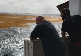 Les mécaniciens observent le radeau depuis le navire.